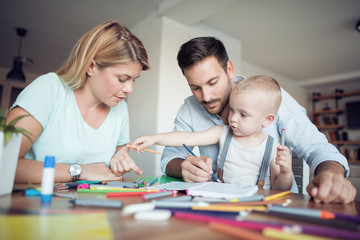 Mom, dad and son draw in the living room