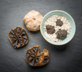 Top view of roasted garlic and rice with truffles over rustic table