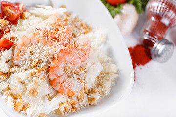 Caesar Salad with Royal shrimps . Comprises iceberg lettuce Leaf and croutons dressed with parmesan cheese. White light background