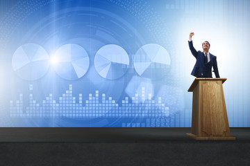 Man businessman making speech at rostrum in business concept
