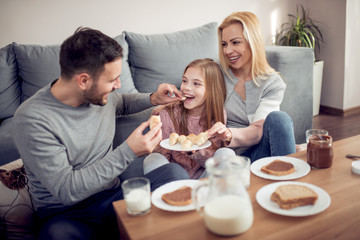 Obraz na płótnie Canvas Modern young family having breakfast