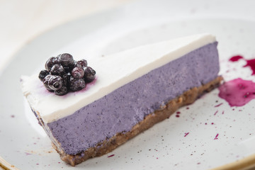 Close up of raw vegan cheesecake with syrup and blueberries