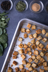 Flay lay of croutons on a baking sheet, with row of ingredients