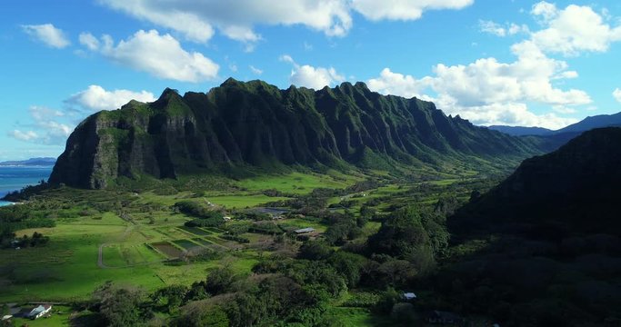 Aerial view flying towards lush jungle mountain landscape on the east side of Oahu in Hawaii 