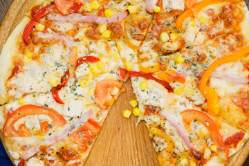 Pizza on a wooden background, cut piece of pizza