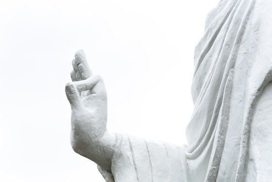 Close-up Buddha hand raised in gesture of Vitarka Mudra isolated on white background. The circle formed by thumb and index finger creates a constant flow of energy information, teaching transmission