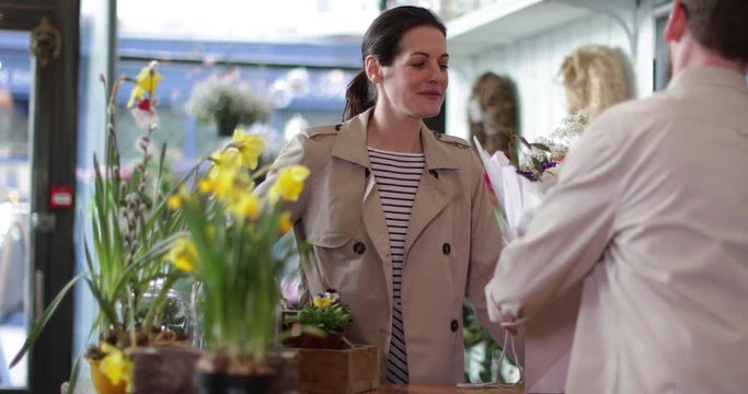 Adult female paying with credit card in a florist