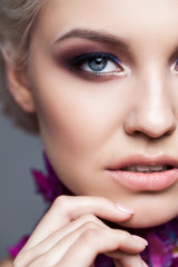 Fototapeta premium Spring girl with trendy make up smoky eyes . Short clarified hairs, with violet petalsof a tulip on her neck