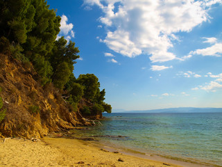 Beautiful seascape with rocky coastline and pine trees at the Aegean Sea near Koukounaries Beach in Skiathos, Greece