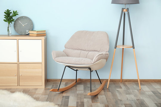 Elegant room interior with comfortable rocking chair near light wall