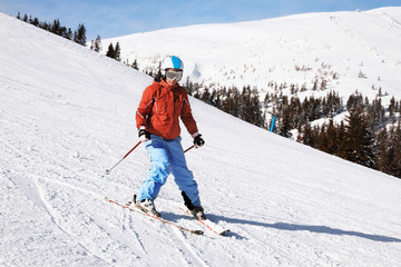 Fototapeta na wymiar Woman skiing downhill at snowy resort. Winter vacation