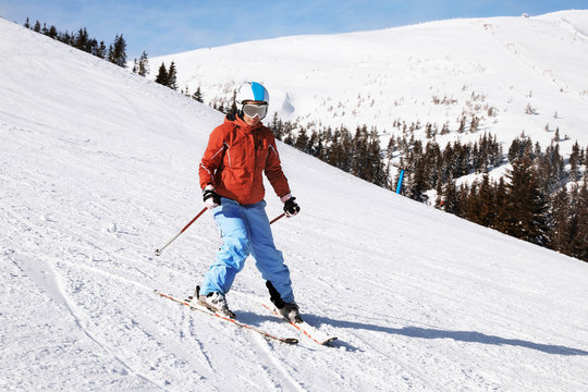 Woman skiing downhill at snowy resort. Winter vacation