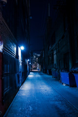 Dark and eerie urban city alley at night.