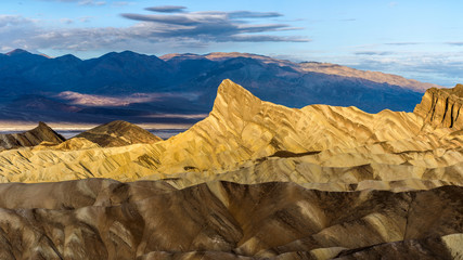 Sunrise at Manly Beacon - Soft first sunlight shining on Manly Beacon and layers of its surrounding rock formations, and revealing their colorful textures. Death Valley National Park, CA, USA.