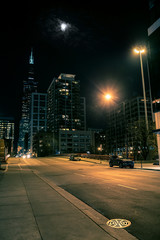 Dark and eerie Chicago city street bridge night scene with the Sears Willis Tower skyscraper and the moon