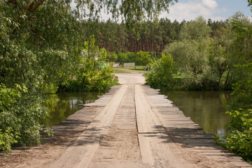 Wooden bridge across river summer landscape