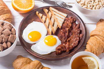 Breakfast with eggs , bacon and croissants