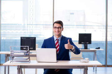 Young handsome businessman employee working in office at desk