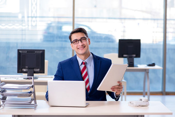 Young handsome businessman employee working in office at desk