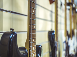close up electric guitars hanging on the wall in a row