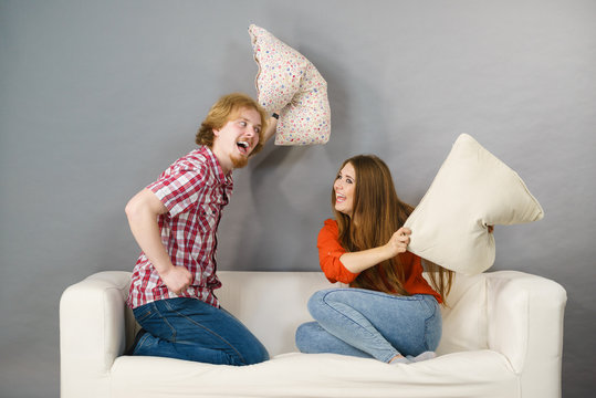 Man And Woman Having Pillow Fight