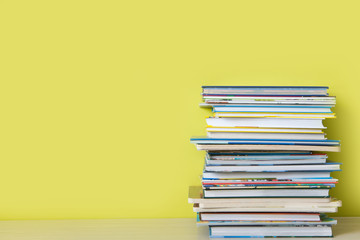 Many children's books are stacked on top of each other. Green background.