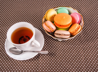 Cup of tea with colorful french macaroons