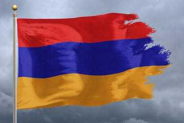 Armenia Flag with torn edges in front of a stormy sky