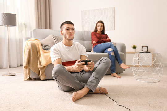 Angry woman and man playing video game at home