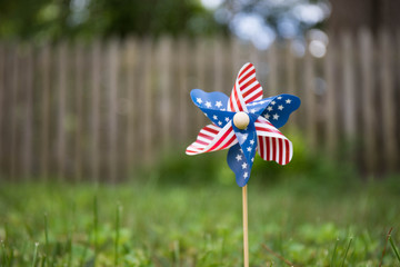 A close up bokeh photo of a pinwheel with the american flag stars and strips pattern.