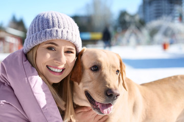 Woman with cute dog outdoors on winter day. Friendship between pet and owner