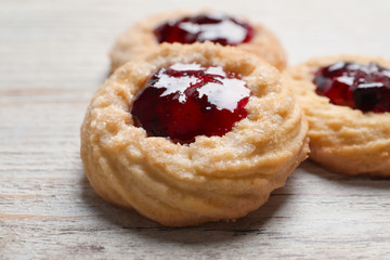 Tasty cookies with jam on wooden background