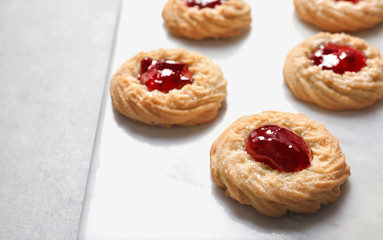 Tasty cookies with jam on stone board