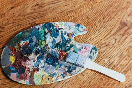 palette with paints on a wooden background
