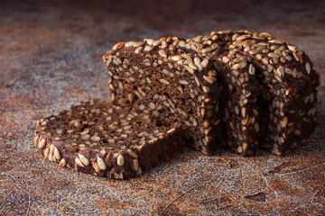 Fresh black bread with sunflower seeds on an old rusty table