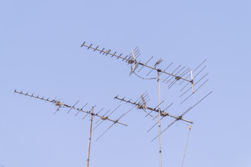 Birds are on the antenna with blue sky