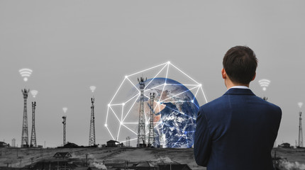 Businessman looking at telecommunication tower and global networking technology with wifi signal signs. Element of this image are furnished by NASA