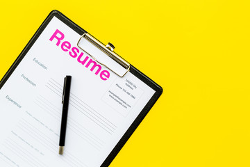 Looking for work concept. Resume on padwith on yellow background top view space for text