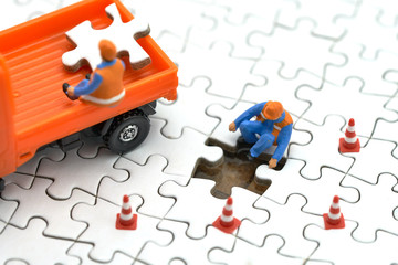 Miniature people Construction worker on white Jigsaw. using as background business concept and...
