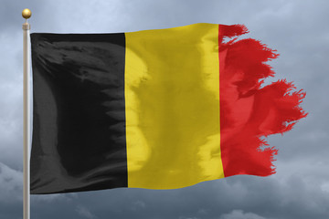Belgium Flag with torn edges in front of a stormy sky