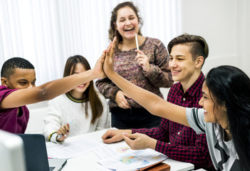 Fototapeta premium Classmates giving a high five teamwork and success concept