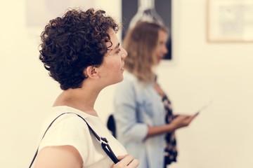 People looking at frames in an exhibition