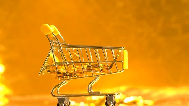 Bitcoin shopping concept with slow motion fallling coins on a shiny golden background