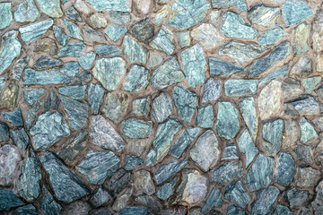 broken natural stone on the wall with cement. Veneer walls turquoise stones