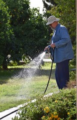 Man spraying water on grass yard