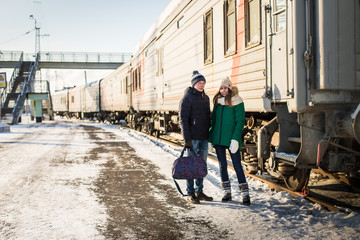 Couple at railway station near train in a winter time