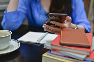 Education Concepts. Asian women are working in a restaurant. Asian women are reading a book in a restaurant.