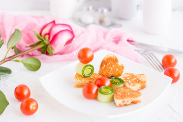 Toasts in the form of heart, cherry and cucumber on a plate. Dish served for lovers and rose.