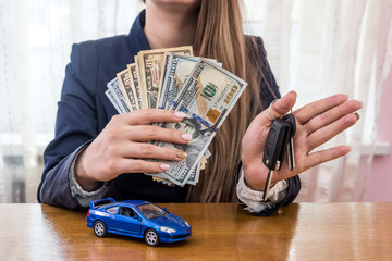 Female hands with dollars, car and keys