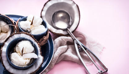 Natural coconut ice cream on a pink background with a spoon for ice cream, the concept of summer and ice cream